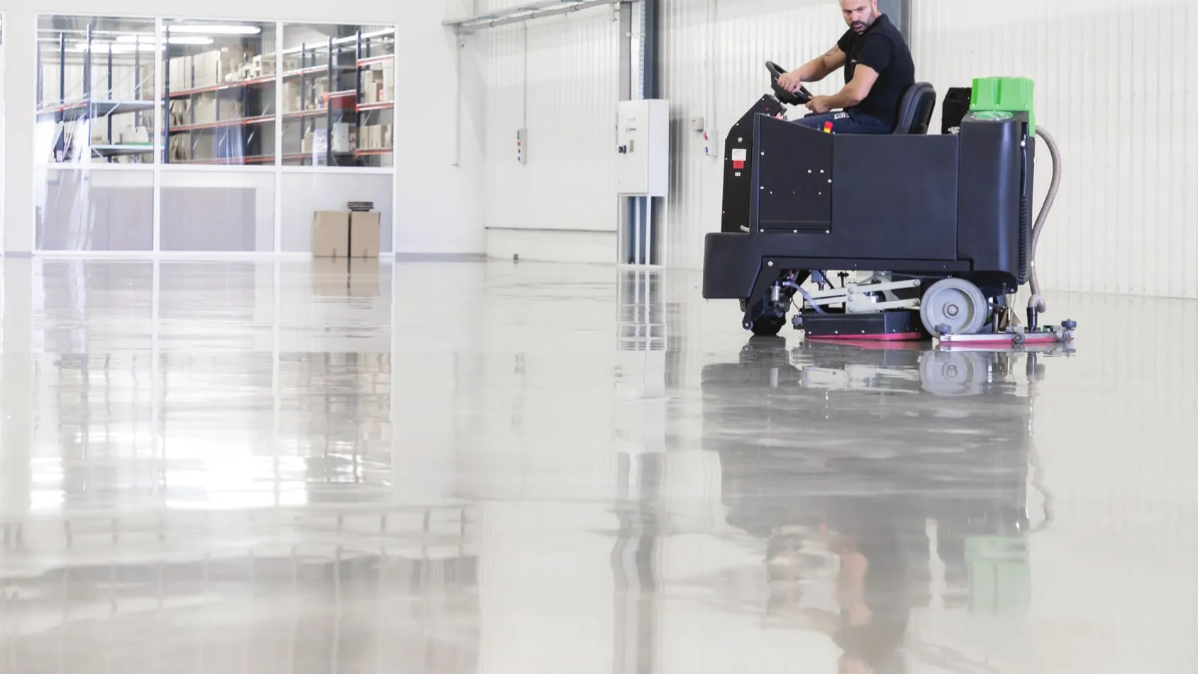 Ride-on scrubber with Suprashine pads in a warehouse